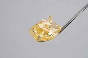 yellow clean cannabis wax, concentrate marijuana and dabbing tool close-up photo