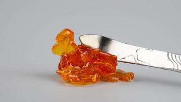 amber yellow cannabis wax concentrate dripping from the dabbing tool photo