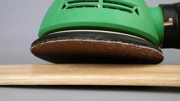 grinding and polish wooden board surface with grind sandpaper machine close up photo