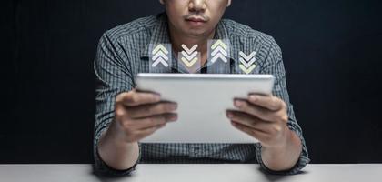 Small businessman looking at sales chart on tablet in his room at home. photo