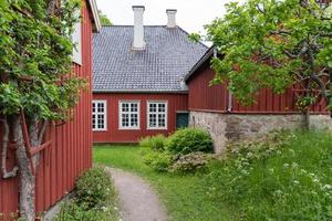 Oslo, Norway. May 29, 2022. An idyllic view of a red farm house and out buildings at The Norwegian Museum of Cultural History in Oslo. photo