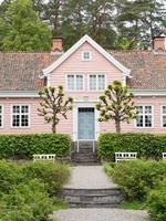 Oslo, Norway. May 29, 2022. A pink house with a blue door at The Norwegian Museum of Cultural History in Oslo. photo
