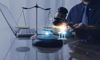 Justice and law concept.Male judge in a courtroom with the gavel, working with, computer and docking keyboard, eyeglasses, on table in morning light photo