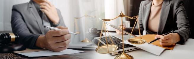 Business and lawyers discussing contract papers with brass scale on desk in office. Law, legal services, advice, justice and law concept picture with film grain effect photo