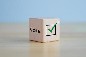 Elections and Voting concept. Check mark and VOTE text on wooden block. photo