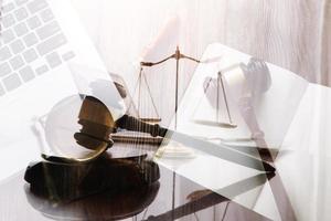 Justice and law concept.Male judge in a courtroom with the gavel, working with, computer and docking keyboard, eyeglasses, on table in morning light photo