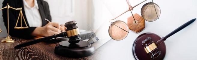 Justice and law concept.Male judge in a courtroom with the gavel, working with, computer and docking keyboard, eyeglasses, on table in morning light photo