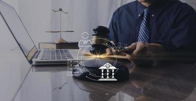 Justice and law concept.Male judge in a courtroom with the gavel, working with, computer and docking keyboard, eyeglasses, on table in morning light photo