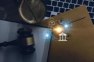 Justice and law concept.Male judge in a courtroom with the gavel, working with, computer and docking keyboard, eyeglasses, on table in morning light photo