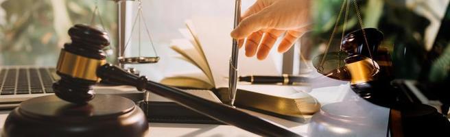 Business and lawyers discussing contract papers with brass scale on desk in office. Law, legal services, advice, justice and law concept picture with film grain effect photo