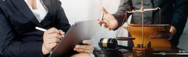 Justice and law concept.Male judge in a courtroom with the gavel, working with, computer and docking keyboard, eyeglasses, on table in morning light photo