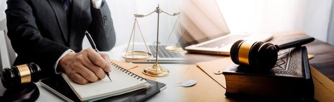 Business and lawyers discussing contract papers with brass scale on desk in office. Law, legal services, advice, justice and law concept picture with film grain effect photo