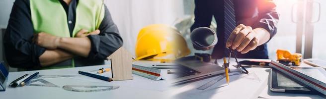 business hand working and laptop with on on architectural project at construction site at office desk in office photo