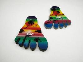 Depok, West Java, Indonesia, 2022 - Fridge magnet shaped like feet, hand crafted as souvenir from Bali after vacation. Isolated on white background photo