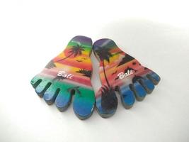 Depok, West Java, Indonesia, 2022 - Fridge magnet shaped like feet, hand crafted as souvenir from Bali after vacation. Isolated on white background photo