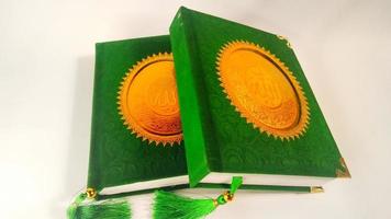 Depok, West Java, Indonesia, 2022 -  Yasin book which is often read by Muslims after prayer. green cover isolated on a white background photo