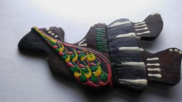 Depok, West Java, Indonesia, 2022 - Fridge magnet shaped like a man from the Asmat tribe in Papua, hand-crafted which he got as a souvenir from Papua after a vacation. Isolated on a white background photo