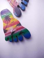 Depok, West Java, Indonesia, 2022 - Fridge magnet shaped like feet, hand crafted as souvenir from Bali after vacation. Isolated on white background photo