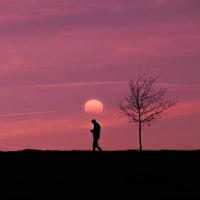 man trekking in the countryside with a beautiful sunset background photo