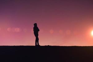 hombre caminando por el campo con un hermoso fondo de puesta de sol foto