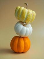stacked decorative pumpkins on yellow color background for autumn season concept.