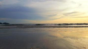 Wide angle view of the sea.  Ocean waves and blue sky mixed with yellow as the sun goes down. photo
