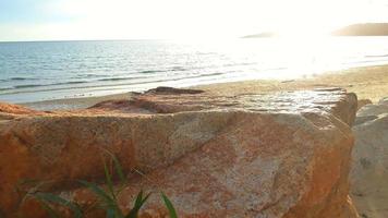 Landscape view of the sea with sunlight hitting rocks placed in front in the evening. photo