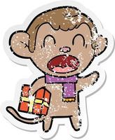 distressed sticker of a shouting cartoon monkey carrying christmas gift vector