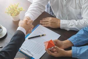 Real estate agents and customers shake hands to congratulate after signing a contract to buy a house with land and insurance, Home sales and home insurance concept. photo