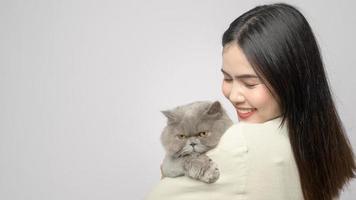 A young woman is holding lovely cat , playing with cat in studio on white background photo