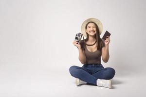 Young happy asian tourist woman over white background studio, travel and holidays concept. photo