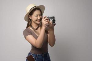 Young happy asian tourist woman over white background studio, travel and holidays concept. photo