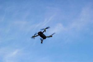 The quadcopter is flying in a blue sky. photo