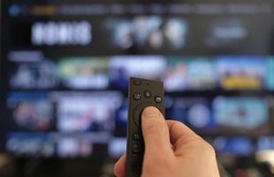 Remote control and screen - binge watching the favorite TV show photo
