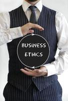 Businessman holding sign with the words Business Ethics photo