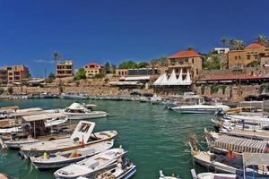 Byblos, Lebanon, 2019 - Boats in the calm water of the port of Byblos, Lebanon, on a sunny day photo