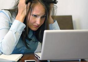 Worried-looking woman with laptop photo