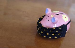 Lockdown and the financial impact - piggy bank wearing a face mask photo