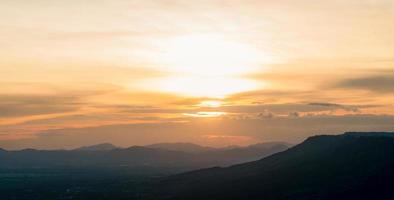 Landscape of mountain range with sunset sky. Mountain at dusk. Orange sky and clouds at sunset. Mountain valley. Mountain layer at dusk. Beauty in nature. Tranquility scene. Beautiful sunset sky. photo