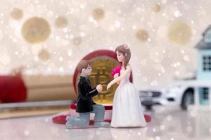 Miniature small doll of couple lovers propose for marriage with romantic valentine moment with background of document asset house car vehicle, metaphor concept trade love money photo