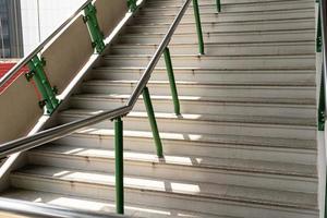 escalera pública en la estación o centro comercial para salida, entrada. escalera dentro del metro subterráneo con pasamanos de acero limpio foto