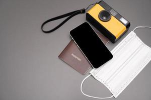 concepto de viaje cámara vintage, teléfono inteligente, pasaporte, sobre fondo gris, con espacio de copia. foto