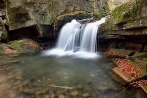 Autumn waterfall in forest photo