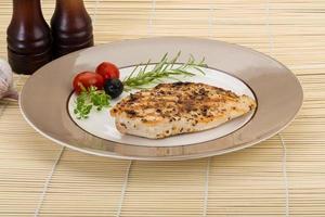 Grilled chichen breast on the plate and wooden background photo