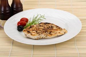 Grilled chichen breast on the plate and wooden background photo