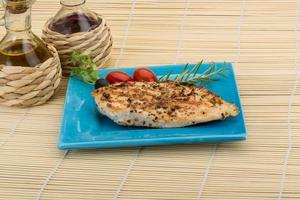 Grilled chichen breast on the plate and wooden background photo