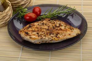 Grilled chichen breast on the plate and wooden background photo