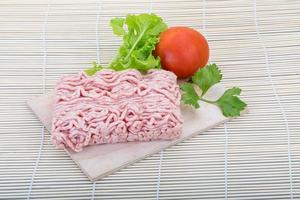 Raw minced pork meat on wooden board and wooden background photo