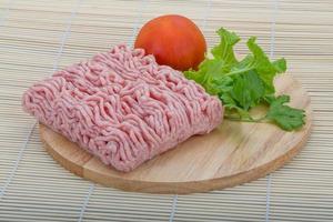 Raw minced pork meat on wooden board and wooden background photo