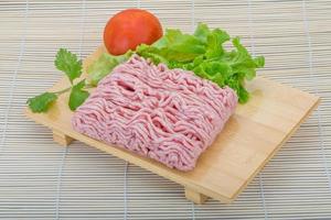 Raw minced pork meat on wooden board and wooden background photo